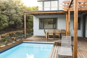 Patio trasero acogedor con alberca con detalles de madera.